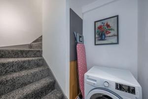a laundry room with a washing machine next to the stairs at *F4GH for your most relaxed & Cosy stay + Free Parking + Free Fast WiFi * in Bramley