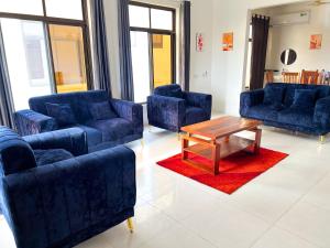 Sala de estar con sofás azules y mesa de centro en Kijiji Villas Nungwi, en Banda Kuu