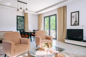 a living room with two chairs and a television at Chic Villa w Pool Garden Fireplace in Sile in Istanbul
