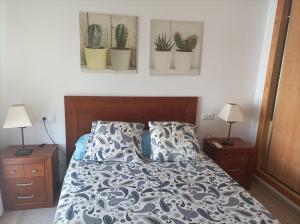 a bedroom with a bed with potted plants on the wall at Ático cala de Mijas in Mijas
