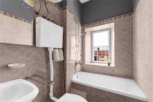 a bathroom with a tub and a toilet and a sink at Joakim Platz in Poreč +14 photos