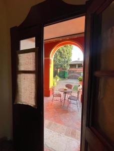 eine offene Tür zu einer Terrasse mit einem Tisch und Stühlen in der Unterkunft B&B Villa la Canonica a Padernello 