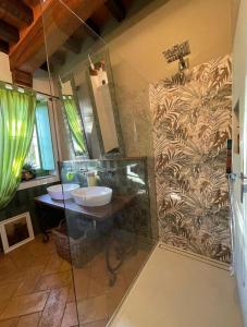 uma casa de banho com 2 lavatórios e um chuveiro em B&B Villa la Canonica a Padernello 