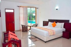 a bedroom with a bed and a table and a window at Siyanco Holiday Resort in Polonnaruwa
