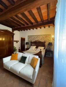 uma sala de estar com um sofá branco em frente a uma cama em B&B Villa la Canonica a Padernello 