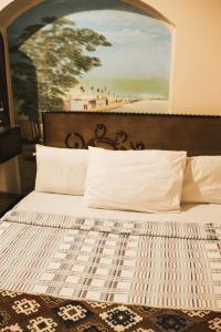 Tuya Hotel في أبو سمبل: غرفة نوم بسرير مع لوحة على الحائط