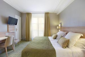 a hotel room with a bed and a desk at Lautrec Opera in Paris