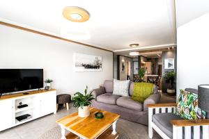 a living room with a couch and a tv at Bayview 104 in Hermanus