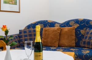魯波爾丁的住宿－Gästehaus beim Schneidersepp，坐在沙发旁的桌子上,一瓶葡萄酒