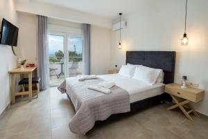 1 dormitorio con 1 cama grande y balcón en Agali Rooms, en Skala Rachoniou