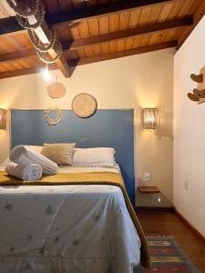 a bedroom with a large bed with a blue headboard at Kanaloa Vibe Stay in Praia do Rosa