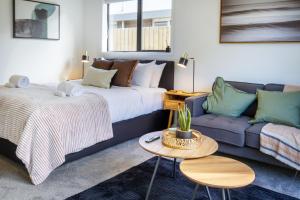 salon z łóżkiem i kanapą w obiekcie Serenity Getaway w mieście Christchurch