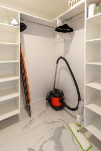 a vacuum cleaner in a room with white shelves at Serenity Getaway in Christchurch