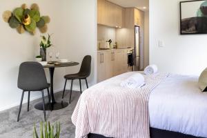 a bedroom with a bed and a table with chairs at Serenity Getaway in Christchurch