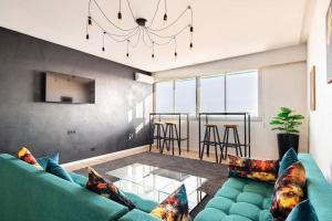 uma sala de estar com um sofá verde e uma mesa de vidro em Rabat vue du ciel, majestueux et panoramique centre ville em Rabat