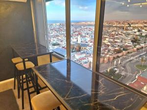 uma mesa e cadeiras num quarto com vista para a cidade em Rabat vue du ciel, majestueux et panoramique centre ville em Rabat