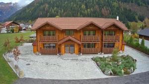 una grande casa in legno con un ampio cortile di Tauern Appartements a Mallnitz