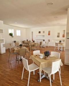 una sala da pranzo con tavoli e sedie in una stanza di Bisus de Jara a Tuili