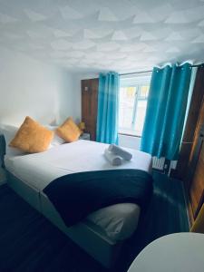 a bedroom with a large bed with blue curtains at Avalon Hotel in Brighton & Hove