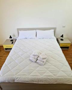 Una cama con dos toallas y dos mesas. en Bisus de Jara, en Tuili