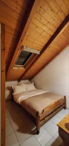 a bed in a room with a wooden ceiling at The Wooden Nest Arachova in Arachova