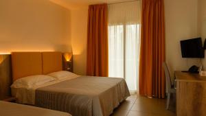 una camera d'albergo con letto e finestra di Hotel San Teodoro a San Teodoro