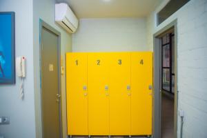 a row of yellow lockers in a room at City Hostel Shymkent in Shymkent