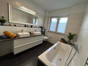 a bathroom with a sink and a bath tub at Exklusive Ferienwohnung bei Berlin, bis 5 Gäste, große Terrasse, Garten in Bestensee
