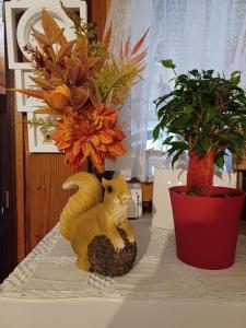 a cat statue sitting on a table next to two plants at Holiday Old stone house in Sveti Ivan Zelina