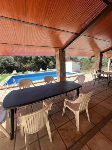 eine Terrasse mit einem Tisch, Stühlen und einem Pool in der Unterkunft Casa Rural Il Consigliere in Córdoba