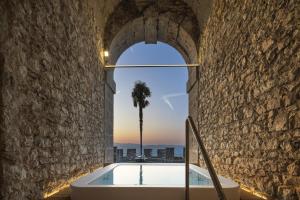 a bath tub in a stone wall with a palm tree at CastelBrando in Cison di Valmarino