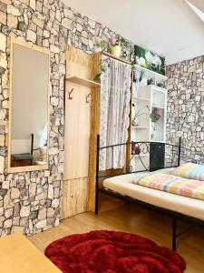 a bedroom with a stone wall with a bed and a mirror at Ferienzimmer Healing und Montuerwohnung in Weißenfels