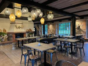 Hotel Pernigele في Jelgavkrasti: مطعم به طاولات وكراسي واضاءات