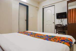 um quarto com uma cama com um cobertor colorido em FabHotel Royal Samrat em Pune