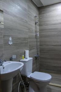 La salle de bains est pourvue de toilettes et d'un lavabo. dans l'établissement Twins Downtown Hotel, à Amman