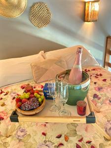 a tray with a bottle of champagne and a basket of fruit at Kanaloa Vibe Stay in Praia do Rosa