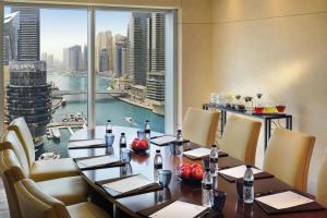 a restaurant with a table with chairs and a large window at Address Marina Mall Suites "Full Marina Views & Balcony " in Dubai