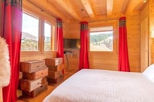 - une chambre avec des rideaux rouges et un lit dans un dortoir dans l'établissement ORTA Chalet, aux Gets