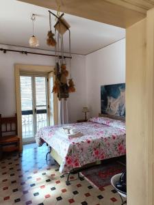 1 Schlafzimmer mit einem Bett mit Blumenbettdecke in der Unterkunft Casa Vacanza Vico Medica in Modica