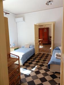 ein Schlafzimmer mit 2 Betten und einem karierten Boden in der Unterkunft Casa Vacanza Vico Medica in Modica