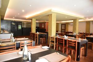 a dining room with tables and chairs in a restaurant at Hotel Haywizz in Port Blair