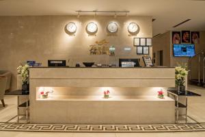 a lobby with a counter with clocks on the wall at Jiwar Hotel in Jeddah