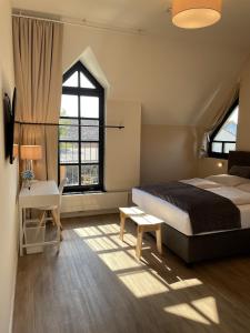 a bedroom with a bed and a desk and window at Haus Karlich in Trausdorf an der Wulka