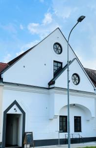 une église blanche avec un feu de rue devant elle dans l'établissement Haus Karlich, à Trausdorf an der Wulka