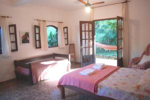 1 dormitorio con cama y ventana grande en Hotel Eco Sítio Nosso Paraíso, en Saquarema