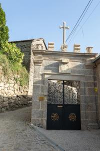 Una iglesia con una puerta con una cruz. en Quinta Flor de Lis, Gerês, en Vieira do Minho