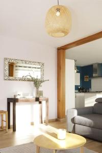 uma sala de estar com um sofá e uma mesa em Maison Le Chapitre by La Boîte En Plus em Senlis