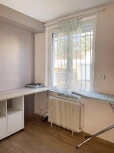 um quarto vazio com uma secretária e uma janela em Maison Le Chapitre by La Boîte En Plus em Senlis