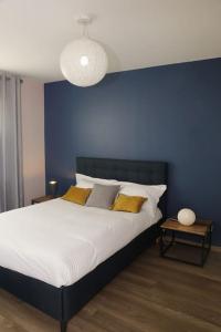 um quarto com uma cama grande e uma parede azul em Maison Le Chapitre by La Boîte En Plus em Senlis