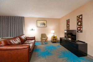 a living room with a couch and a flat screen tv at Days Inn by Wyndham Coeur d'Alene in Coeur d'Alene